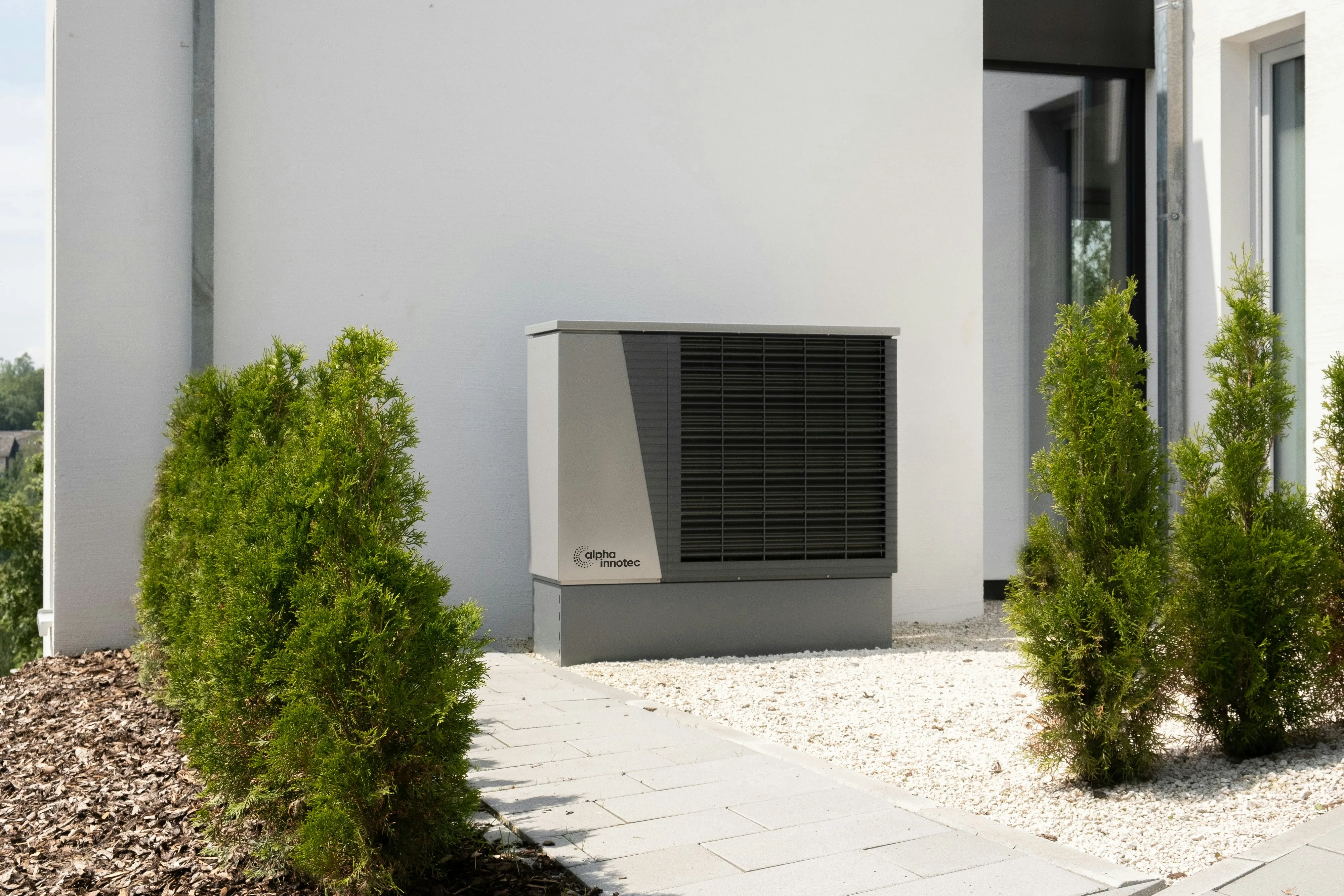 An air source heat pump outdoor unit installed against the exterior wall of a property