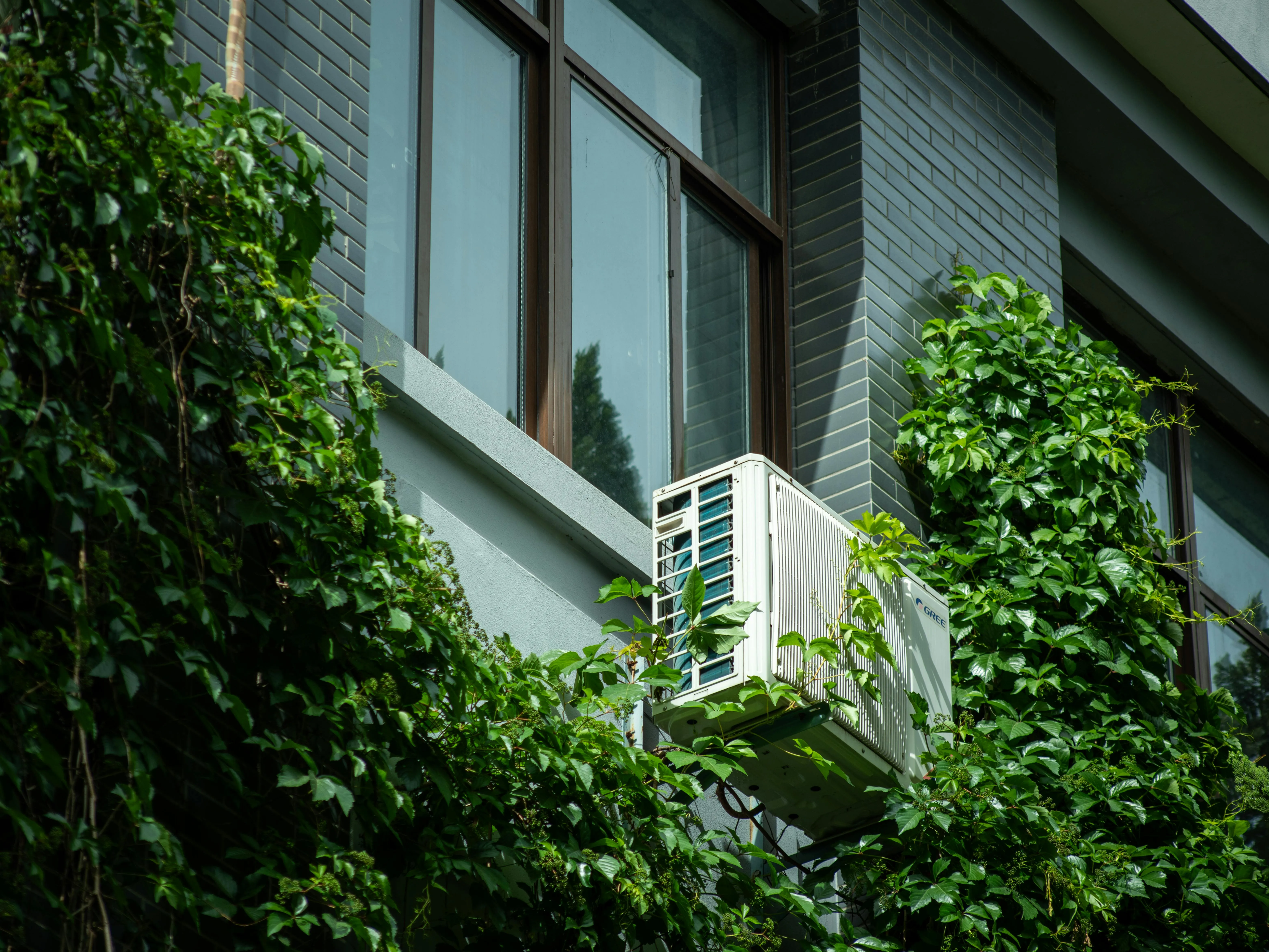 Modern building with an exterior-mounted air-source unit — correct sizing is critical to performance