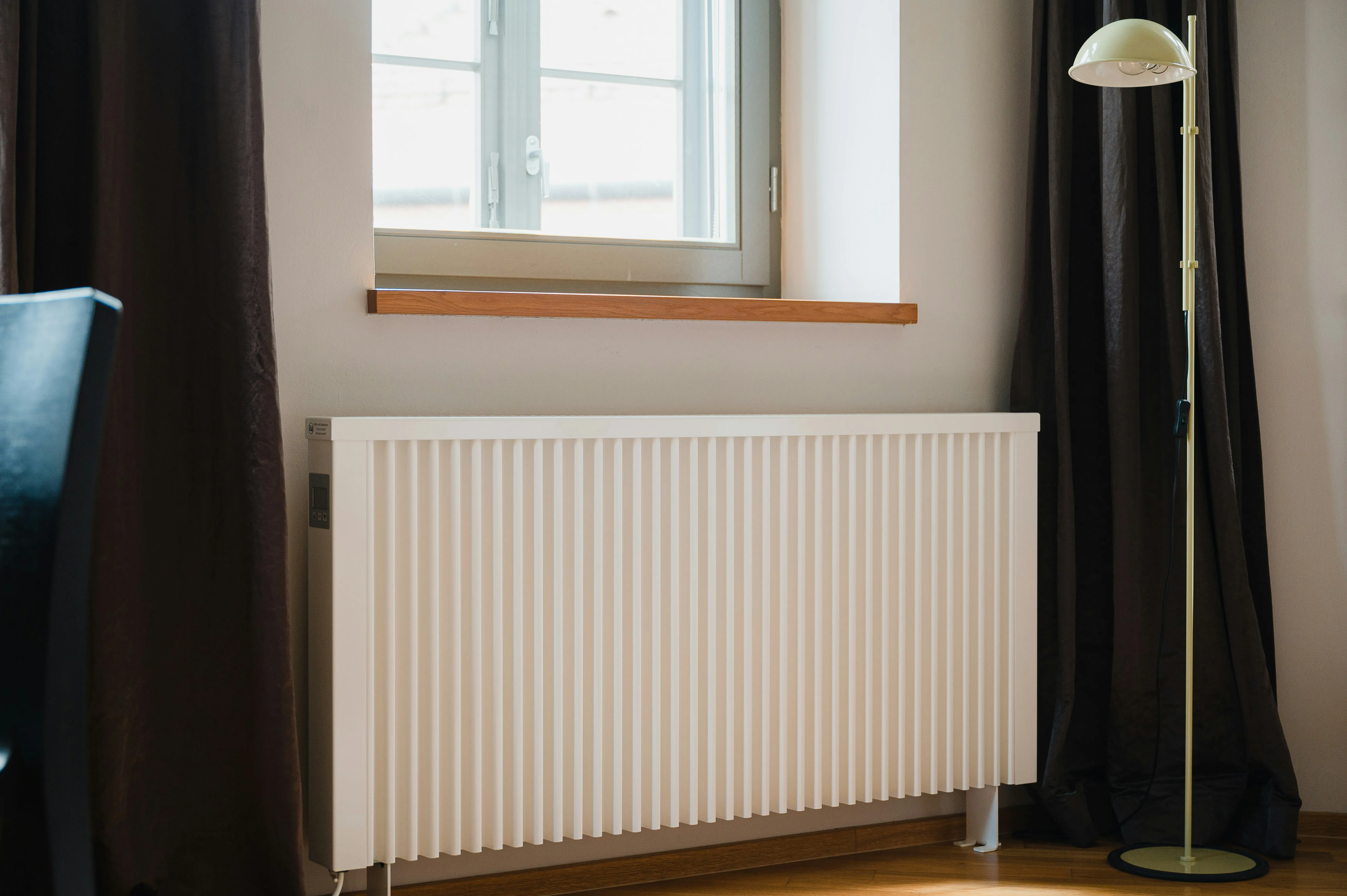 Modern radiator with digital thermostatic control — flow temperature shapes the heat each radiator delivers